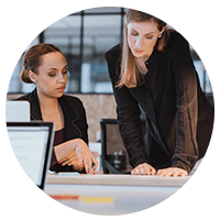 Two business women review compliance information in office
