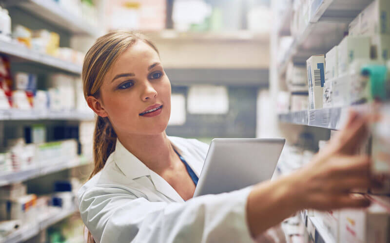 Woman pharmacist in Pharmacy with tablet device