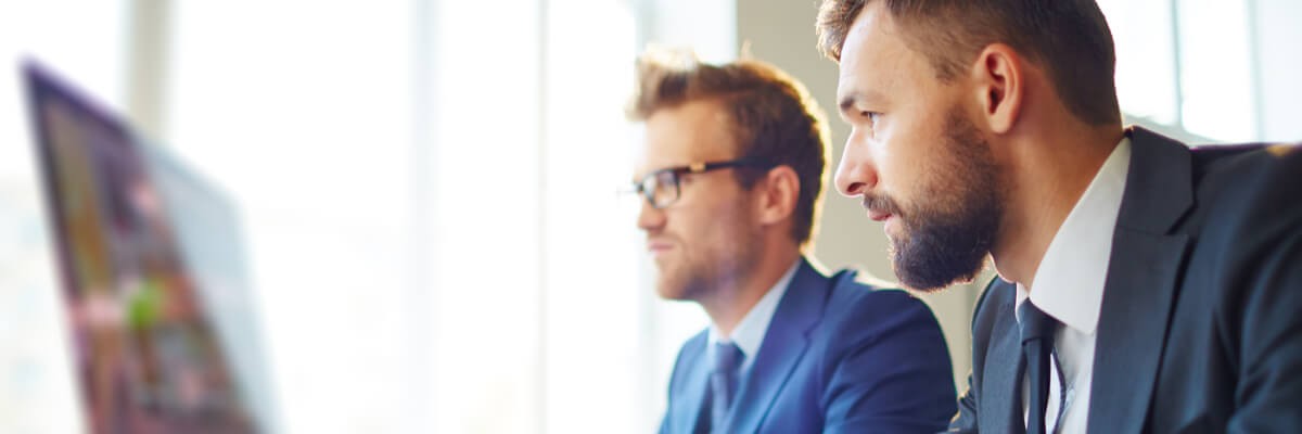 Photo of two business professionals collaborating on desktop computer