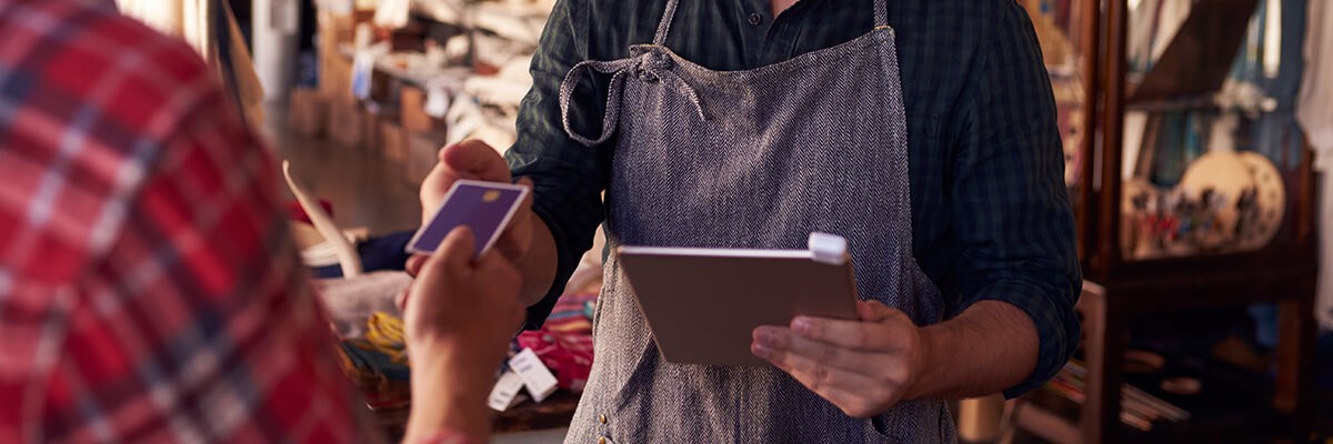 Sales assistant with credit card reader on digital tablet