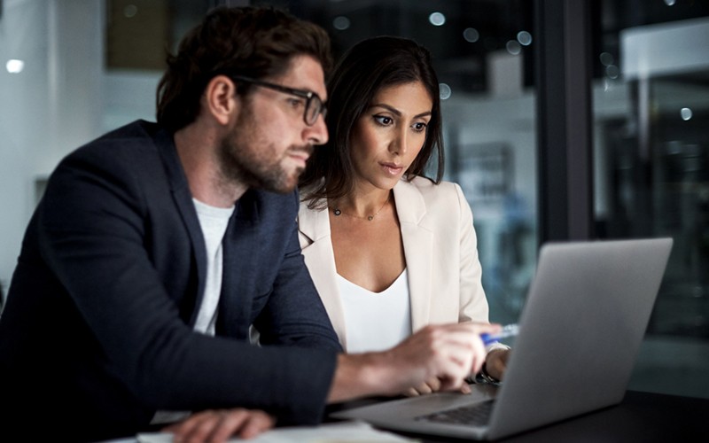 Man and woman looking at files on a laptop