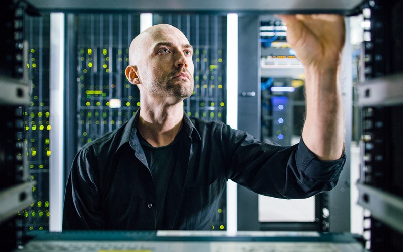 IT engineer reviews open server rack for new rack mounted hard drive