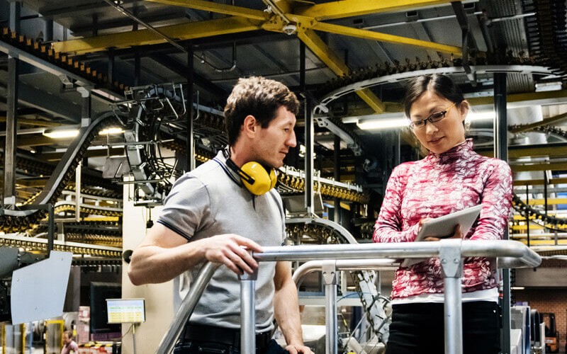 Engineers discuss software tools in modern manufacturing plant