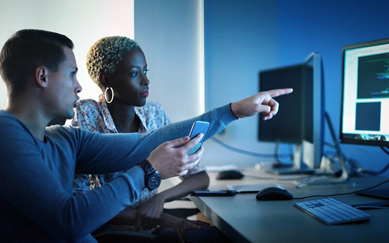 IT professionals working on desktop computer 