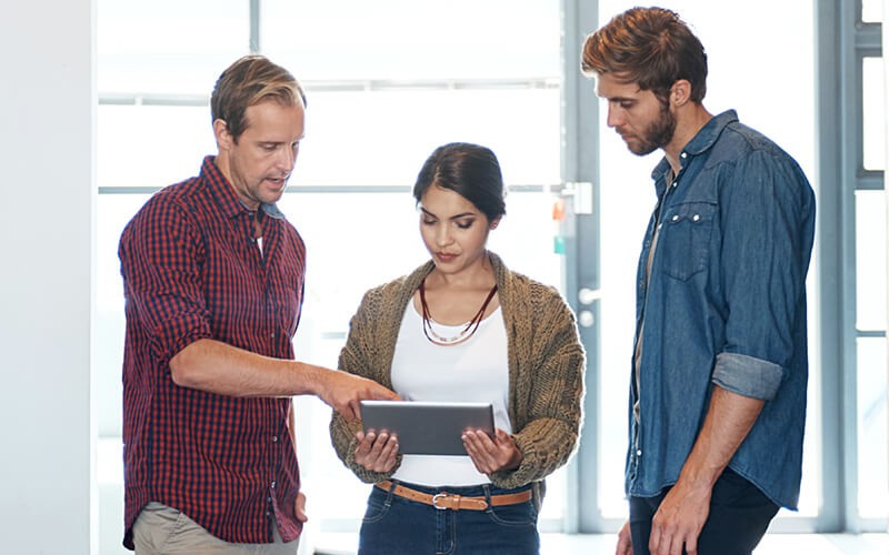 Team gathered around tablet discussing cloud consumption models