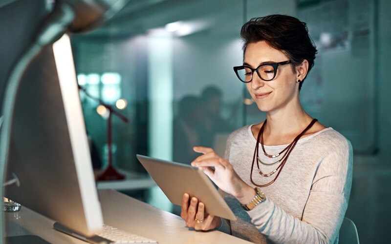 Female in glasses working from tablet