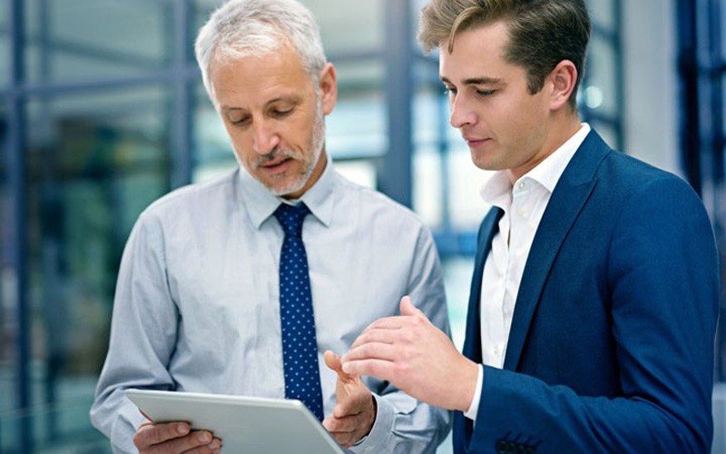Business professionals using tablet in office