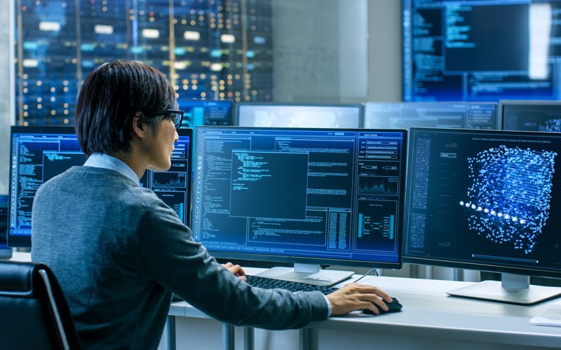 Analyist working with data on multiple displays